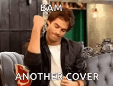 a man is sitting on a couch with his fist in the air and the words bam another cover below him