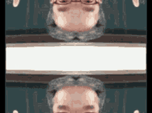 a man with glasses and a beard is reflected in a mirror .