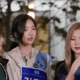 a girl wearing a blue sash with the number 5 on it