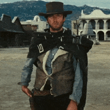 a man wearing a cowboy hat and a cape has the letter d on his vest