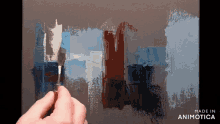 a person is painting on a canvas with the words made in animotica on the bottom right