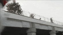 a bridge with a fence in the background and trees on the side