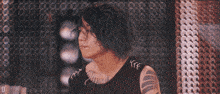 a woman with blue hair is wearing a black lace up top with a tattoo on her arm