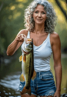 a woman holding a large fish in her hand