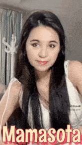 a woman with long black hair is wearing a white tank top with the name mamasota written on it