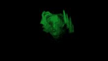 a woman 's face is glowing in the dark with green flames coming out of it