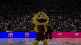 a mascot stands on a basketball court with a crowd behind him