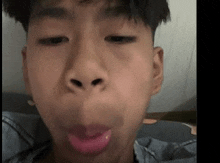 a young boy is making a funny face with his tongue sticking out of his mouth .