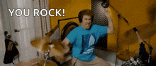 a man in a blue shirt is playing drums and the words you rock are on the bottom