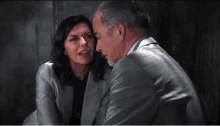 a man and a woman are sitting next to each other and the woman is kissing the man on the cheek