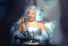 a woman in a fairy costume is holding a trophy
