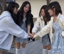 a group of girls are putting their hands together