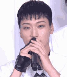 a close up of a person holding a microphone in their mouth