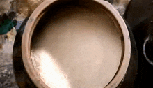 a large wooden bowl filled with a brown liquid
