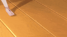 a woman 's bare feet are standing on a wooden floor .