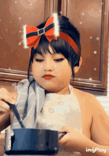 a girl with a red bow on her head is holding a knife