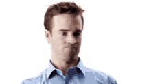 a man in a blue shirt is holding a white object in his hand