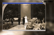 a computer screen shows a bride and groom walking down the aisle at their wedding