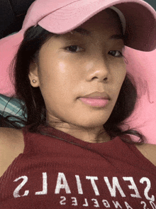 a woman wearing a pink hat and a red tank top with 2jaitm32 written on it