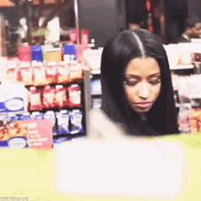 a woman is standing in front of a grocery store with a sign that says ' ice cream ' on it