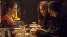 a woman wearing a shirt that says ' chicago ' on it sits at a bar with other people
