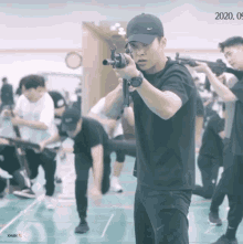 a man holding a gun in a gym with the date 2020 09
