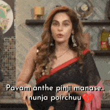 a woman in a black saree is standing in a kitchen holding a knife .