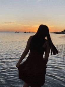 a woman in a red dress is standing in the water