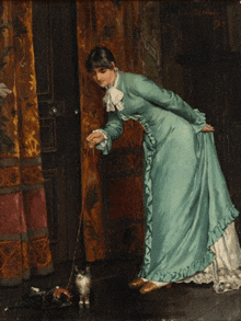 a woman in a blue dress is playing with a cat