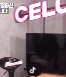 a cell phone is sitting in front of a sign that says cell