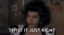 a woman with curly hair is sitting in a chair with the words `` twist it just right '' written on her face .
