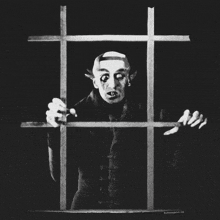 a black and white photo of a vampire behind bars with the website behindthejail.com at the bottom
