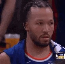 a basketball player with dreadlocks and a beard is looking at something .