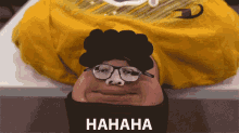 a man wearing glasses and a yellow shirt with the word hahaha on the bottom right