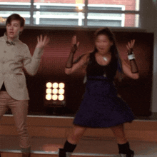 a man and a woman are dancing in front of a wall with circles on it