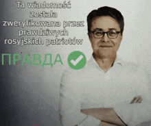 a man with his arms crossed stands in front of a sign that says ta wiadomosc