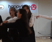 a group of girls are dancing in front of a sign that says happylife