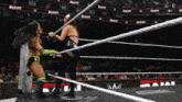two women are wrestling in a ring with the word raw on the walls