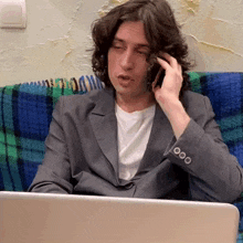 a man in a suit is talking on a cell phone