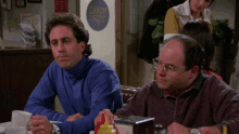 two men sit at a table in front of a 2 hour sign