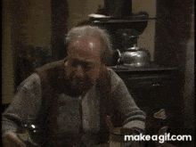 a man is drinking from a bottle with the words make a gif.com written below him
