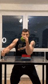 a man with a tattoo on his arm is holding a green object in his hands