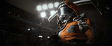 a man in a space suit is standing in a dark room with lights behind him