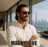 a man wearing sunglasses and a white shirt stands in front of a window with the word magnifique written above him