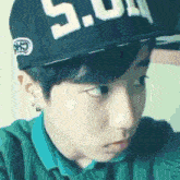 a close up of a person wearing a hat with the number 5.0 on it
