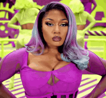 a woman with purple and blue hair is wearing a purple top .