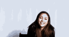 a woman is sitting in a chair and smiling with her mouth open .
