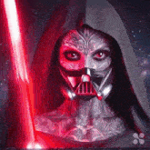 a woman with a darth vader mask on her face holds a red light saber