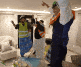 a group of people are dancing in a living room with an umbrella on the floor