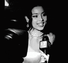a black and white photo of a woman holding a microphone that says et on it